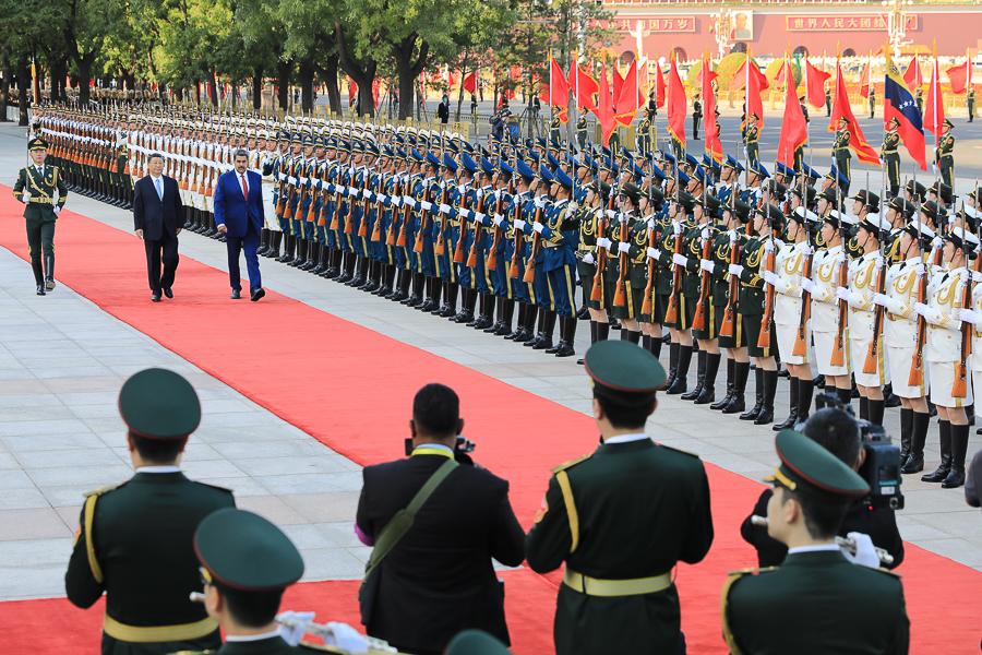 President Nicolás Maduro receives honors with waving flags under the Beijing sky